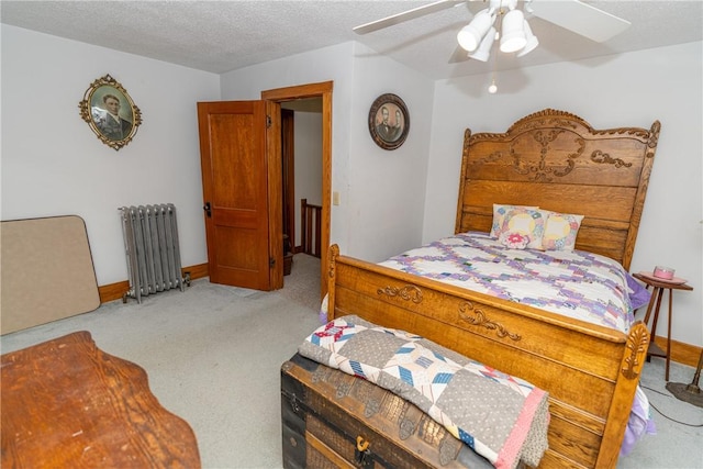 carpeted bedroom with radiator, ceiling fan, a textured ceiling, and baseboards