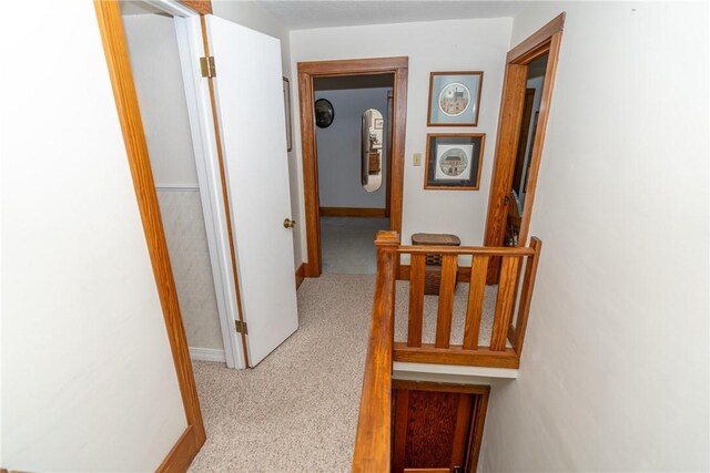 hallway with carpet floors and baseboards