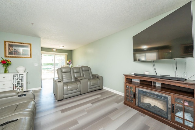 102 Wall Ave, Des Moines, IA 50315 - living room featuring wood finished floors, a textured ceiling, and baseboards
