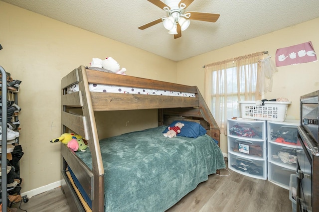 102 Wall Ave, Des Moines, IA 50315 - bedroom featuring wood finished floors, a textured ceiling, a ceiling fan, and baseboards
