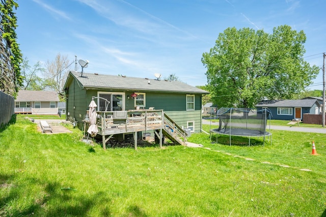 102 Wall Ave, Des Moines, IA 50315 - rear view of house with a deck, a trampoline, a lawn, and stairway