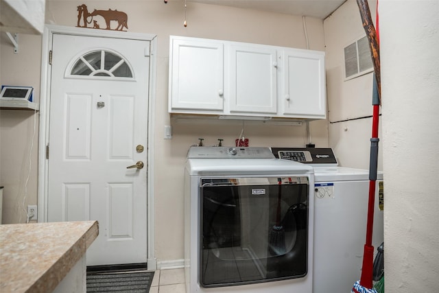 laundry area featuring cabinet space, washer and clothes dryer, and light tile patterned flooring
