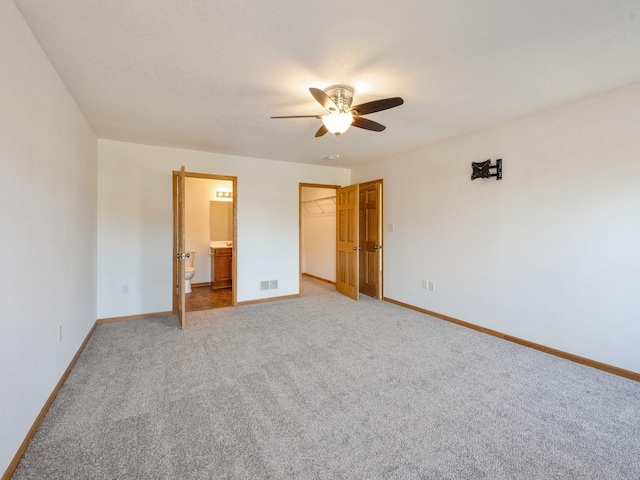 1132 S Goodrich St, Colfax, IA 50054 - unfurnished bedroom featuring light colored carpet, baseboards, and a walk in closet