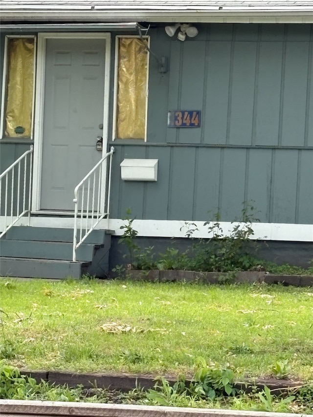 1344 21st St, Des Moines, IA 50311 - view of exterior entry featuring board and batten siding and a lawn