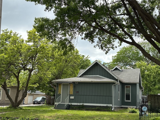 1344 21st St, Des Moines, IA 50311 - view of front of home featuring a shingled roof, a garage, board and batten siding, and a chimney