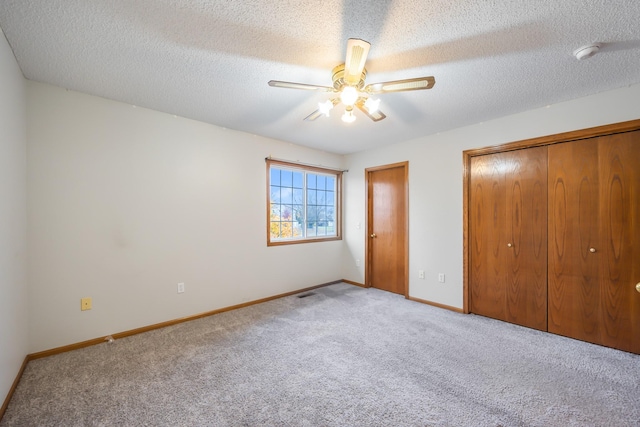 1634 Prairie Cir, Altoona, IA 50009 - unfurnished bedroom featuring carpet, baseboards, a closet, ceiling fan, and a textured ceiling
