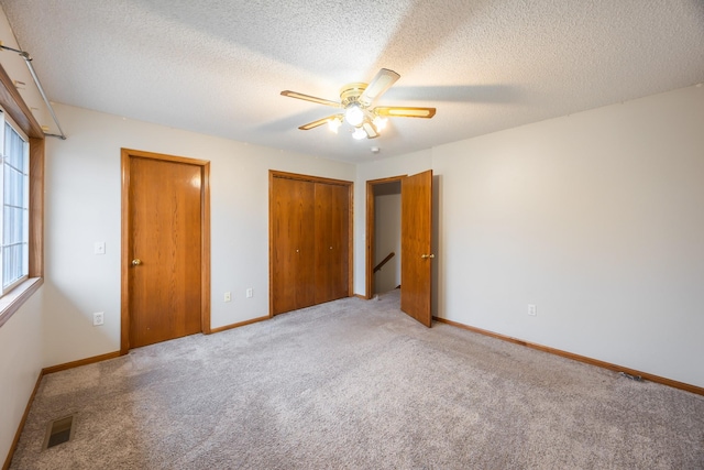1634 Prairie Cir, Altoona, IA 50009 - unfurnished bedroom featuring carpet floors, a textured ceiling, ceiling fan, and baseboards