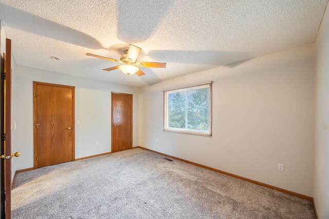 1634 Prairie Cir, Altoona, IA 50009 - unfurnished bedroom featuring carpet, a textured ceiling, baseboards, and ceiling fan