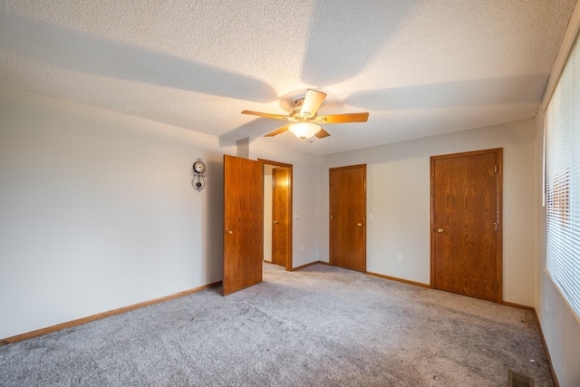 1634 Prairie Cir, Altoona, IA 50009 - unfurnished bedroom with carpet flooring, ceiling fan, a textured ceiling, baseboards, and two closets