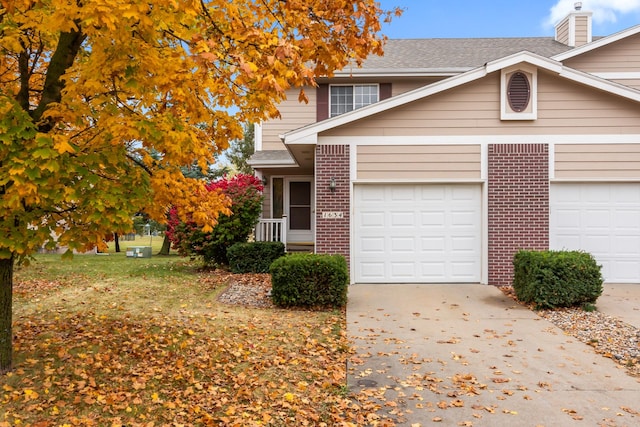 1634 Prairie Cir, Altoona, IA 50009 - view of front of home with brick siding, driveway, a garage, a chimney, and roof with shingles