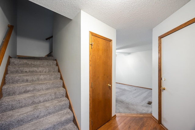 1634 Prairie Cir, Altoona, IA 50009 - stairs with wood finished floors, a textured ceiling, and baseboards