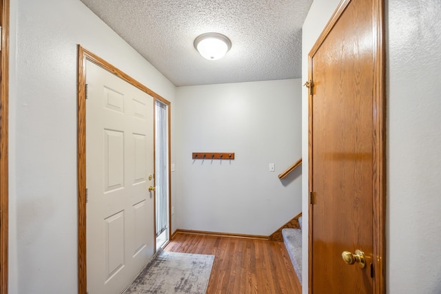 1634 Prairie Cir, Altoona, IA 50009 - entrance foyer with light wood-type flooring, a textured ceiling, baseboards, and stairs