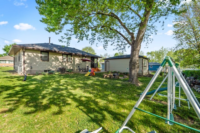 3101 Roblang Ct, Des Moines, IA 50317 - rear view of property featuring a playground, a yard, an outdoor structure, and central AC unit