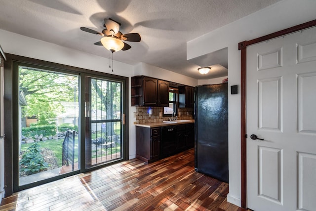 3101 Roblang Ct, Des Moines, IA 50317 - kitchen with freestanding refrigerator, light countertops, tasteful backsplash, dark brown cabinetry, and dark wood-type flooring