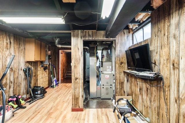 3101 Roblang Ct, Des Moines, IA 50317 - below grade area with wood walls, heating unit, wood finished floors, and stairs