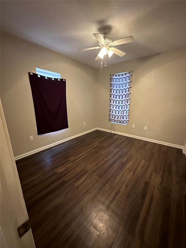 2400 SE 8th St, Des Moines, IA 50315 - unfurnished room featuring dark wood-type flooring, a ceiling fan, and baseboards