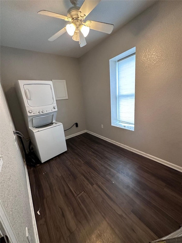 2400 SE 8th St, Des Moines, IA 50315 - spare room featuring stacked washer and clothes dryer, dark wood-style flooring, baseboards, and ceiling fan