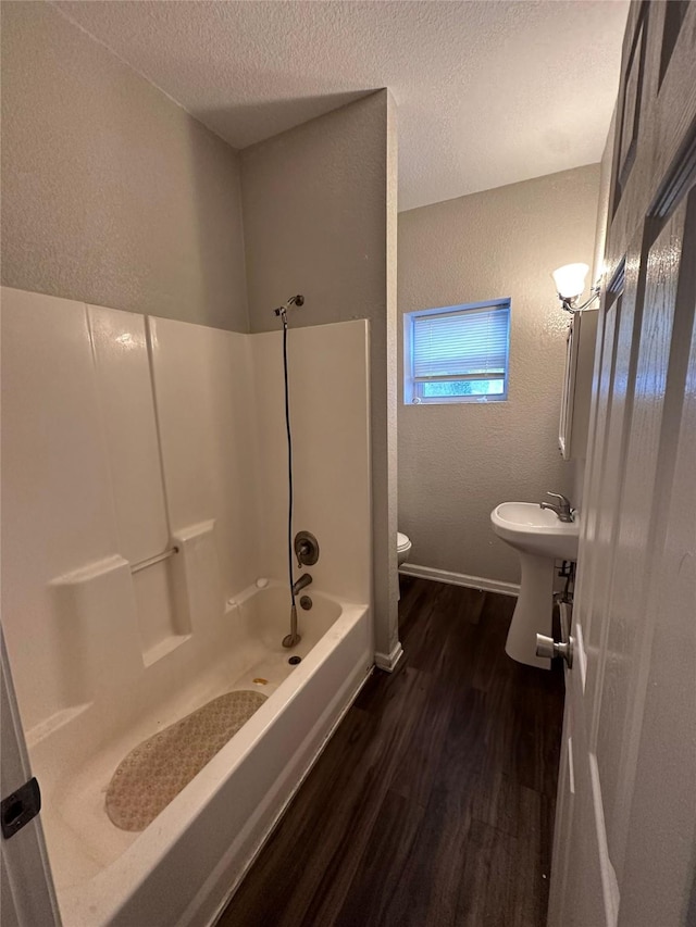 2400 SE 8th St, Des Moines, IA 50315 - bathroom with a textured wall, wood finished floors, toilet, a textured ceiling, and shower / bathtub combination