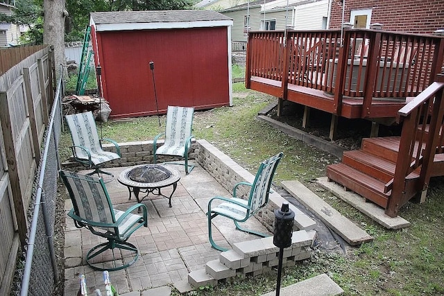 619 Palmer Pl, Des Moines, IA 50315 - fenced backyard featuring an outdoor fire pit, a storage shed, a deck, an outdoor structure, and a patio area