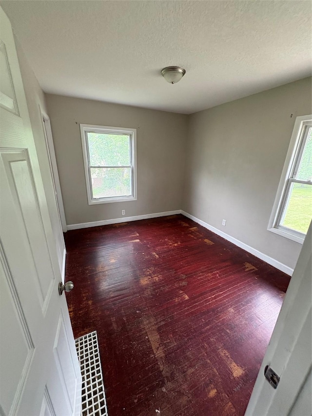 2810 Payne Rd, Des Moines, IA 50310 - spare room featuring baseboards, wood finished floors, and a textured ceiling
