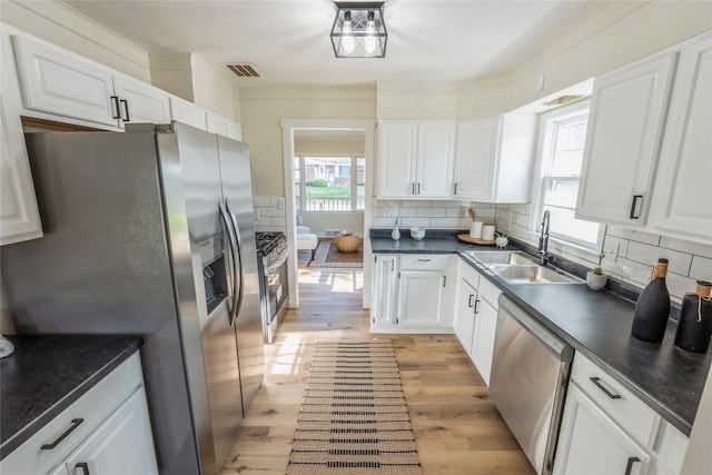 1916 Locust St, West Des Moines, IA 50265 - kitchen with stainless steel appliances, dark countertops, and white cabinetry