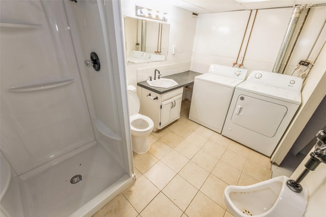 1916 Locust St, West Des Moines, IA 50265 - bathroom featuring washing machine and dryer, a stall shower, tile patterned floors, toilet, and vanity
