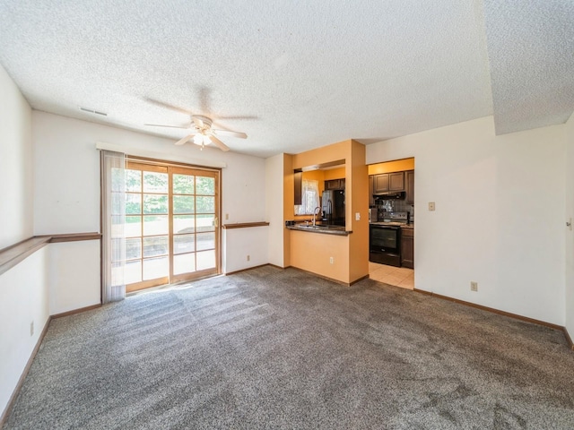 5200 Twana Dr, Des Moines, IA 50310 - unfurnished living room with ceiling fan, a textured ceiling, carpet floors, and baseboards
