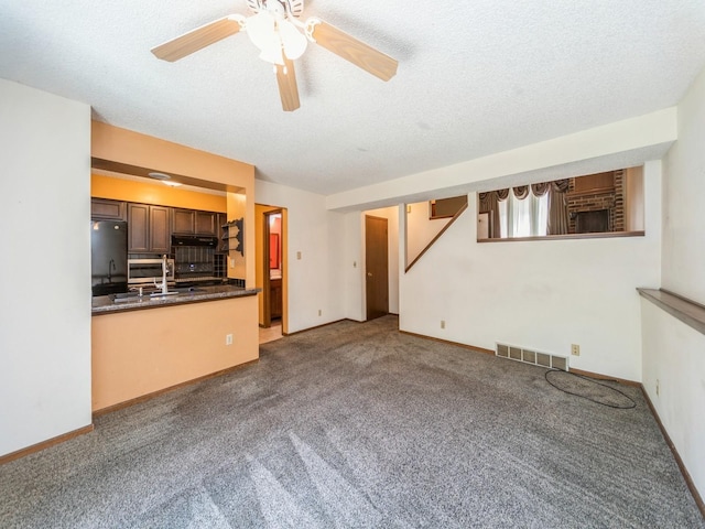 5200 Twana Dr, Des Moines, IA 50310 - unfurnished living room featuring a ceiling fan, carpet, a sink, a textured ceiling, and baseboards