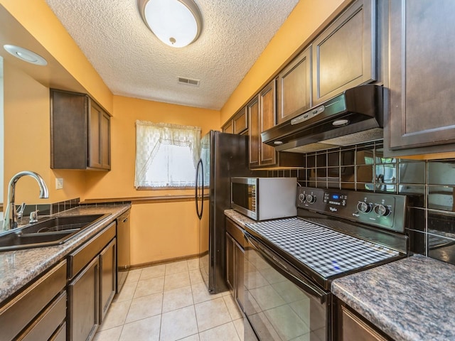 5200 Twana Dr, Des Moines, IA 50310 - kitchen featuring appliances with stainless steel finishes, under cabinet range hood, a sink, decorative backsplash, and a textured ceiling