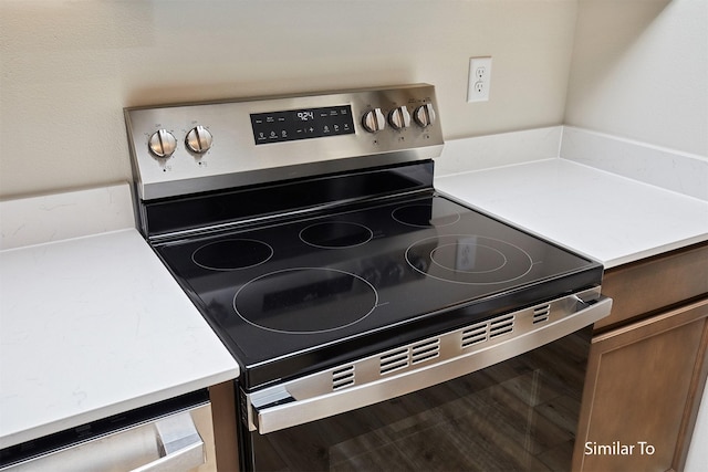 kitchen view of stainless steel electric range oven and light countertops