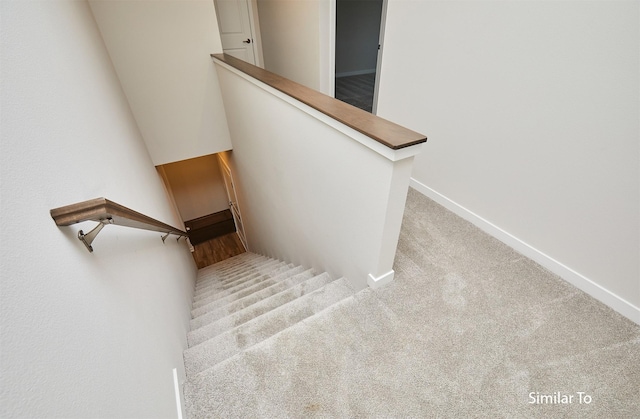 stairway with baseboards and carpet