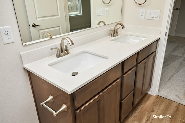 full bath with double vanity and wood finished floors