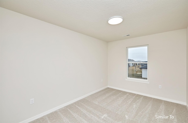 spare room with baseboards and carpet floors