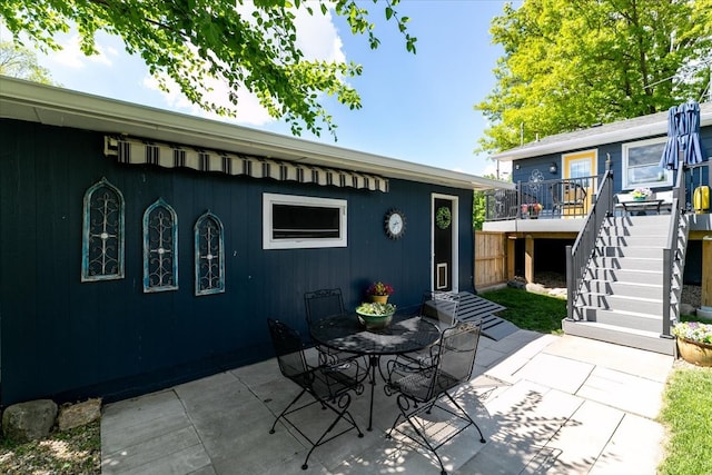 view of patio featuring stairway, a deck, and outdoor dining area