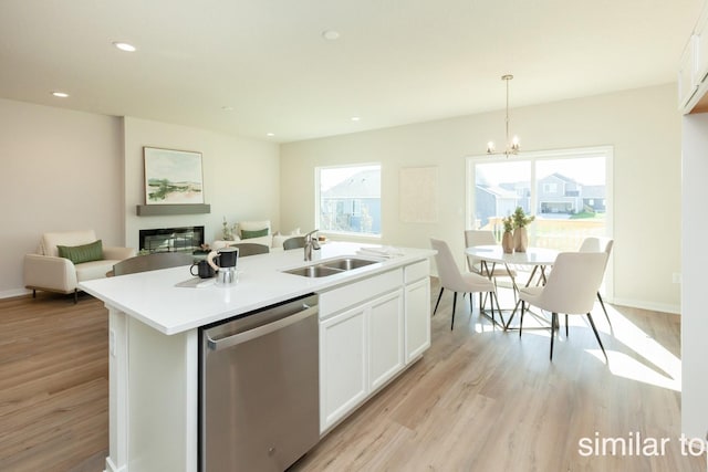 kitchen featuring stainless steel dishwasher, a sink, light wood-type flooring, white cabinetry, and recessed lighting
