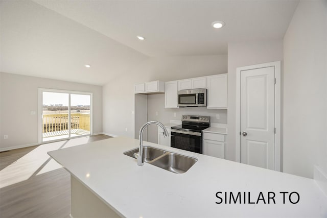 6565 NE 11th Ct, Des Moines, IA 50313 - kitchen with appliances with stainless steel finishes, a sink, vaulted ceiling, light wood-type flooring, and white cabinets