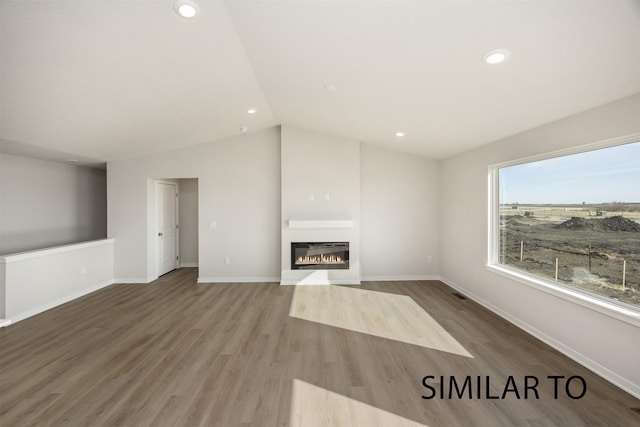 6557 NE 11th Ct, Des Moines, IA 50313 - unfurnished living room with a glass covered fireplace, lofted ceiling, wood finished floors, and recessed lighting