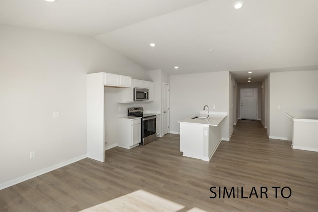 6557 NE 11th Ct, Des Moines, IA 50313 - kitchen featuring appliances with stainless steel finishes, white cabinetry, vaulted ceiling, light wood-type flooring, and recessed lighting