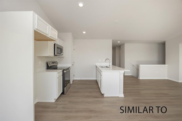 6557 NE 11th Ct, Des Moines, IA 50313 - kitchen with appliances with stainless steel finishes, recessed lighting, light wood-style flooring, white cabinetry, and light countertops