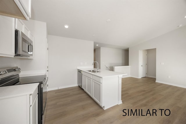 6557 NE 11th Ct, Des Moines, IA 50313 - kitchen with appliances with stainless steel finishes, a peninsula, white cabinets, light wood-style flooring, and recessed lighting