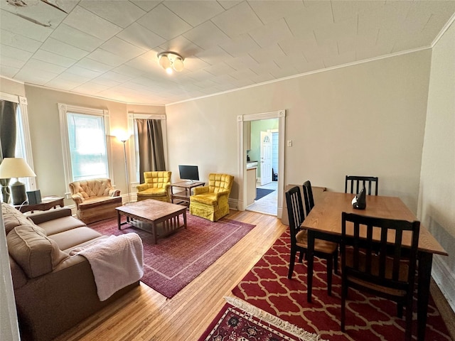 living area featuring ornamental molding and wood finished floors