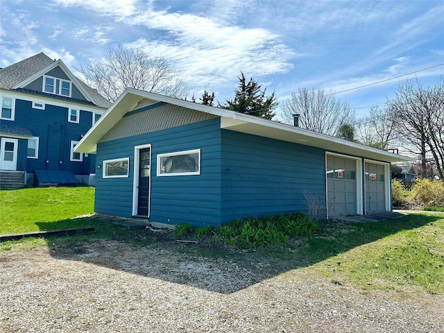 rear view of house with a garage and a yard