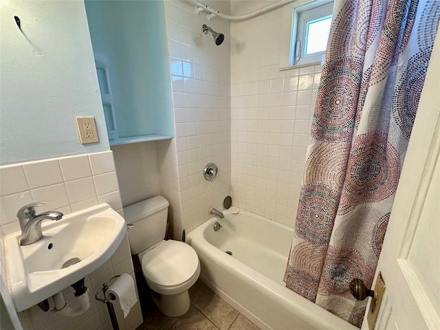 full bath featuring tile walls, toilet, shower / tub combo with curtain, a sink, and tile patterned floors