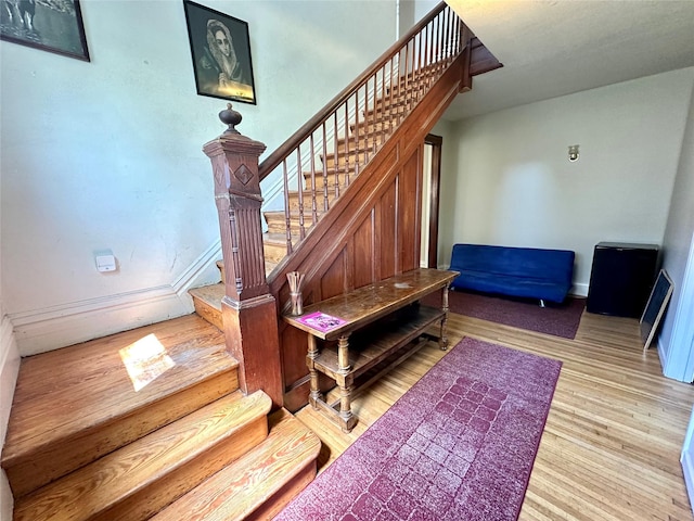stairs featuring wood finished floors and baseboards