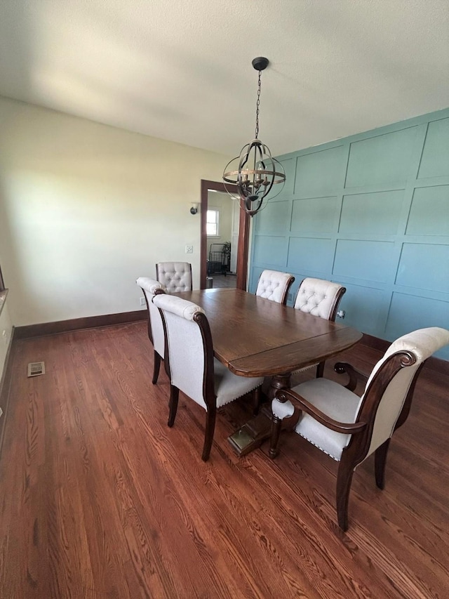 1913 N 1st St, Winterset, IA 50273 - dining area featuring a chandelier, wood finished floors, and baseboards