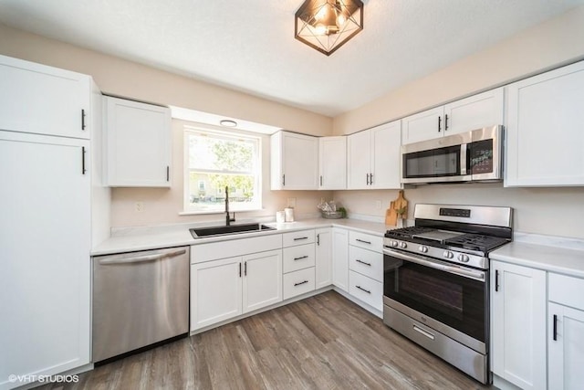 930 Forest Ave, Des Moines, IA 50314 - kitchen with appliances with stainless steel finishes, a sink, light countertops, and white cabinets