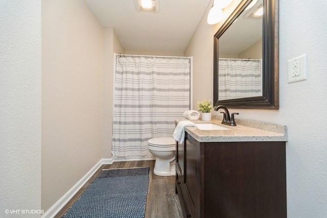 930 Forest Ave, Des Moines, IA 50314 - bathroom featuring wood finished floors, vanity, toilet, and baseboards