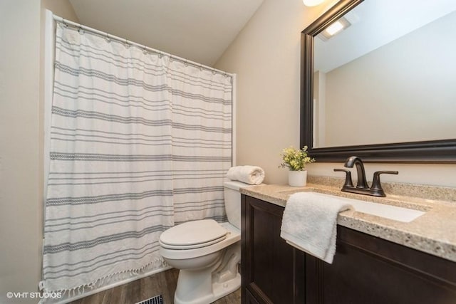 930 Forest Ave, Des Moines, IA 50314 - full bath with wood finished floors, toilet, vanity, and lofted ceiling