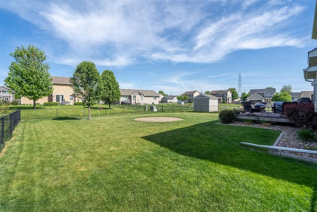 view of yard featuring a residential view and a storage unit