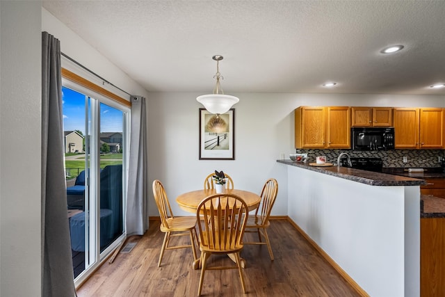 dining area featuring wood finished floors, recessed lighting, a textured ceiling, and baseboards